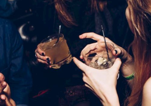 People are socializing and enjoying drinks at what looks like a club or bar. They are engaged in conversation and appear to be having a good time.